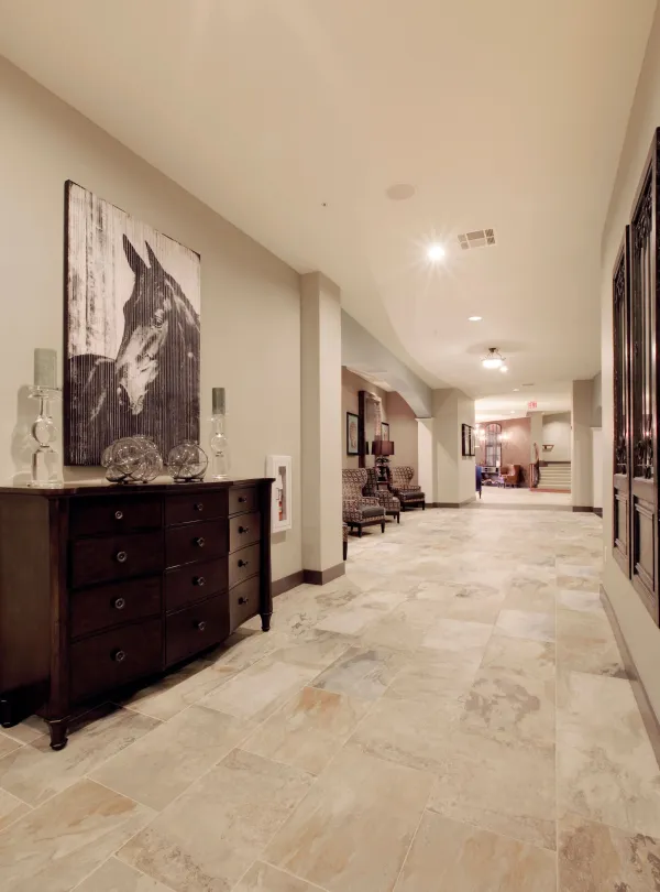 The main-floor common area with stone-tile floors and a lounge beyond